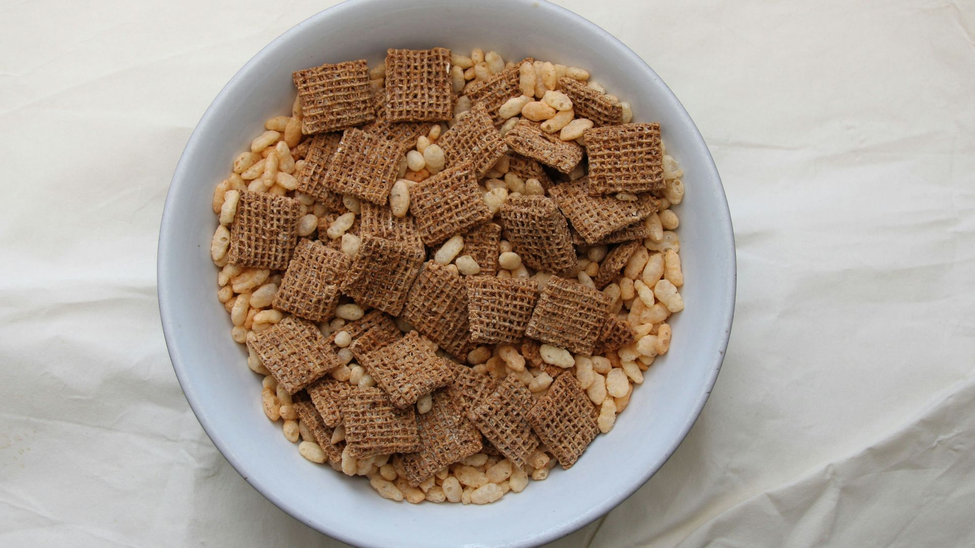 a white bowl filled with cereal on top of a white table