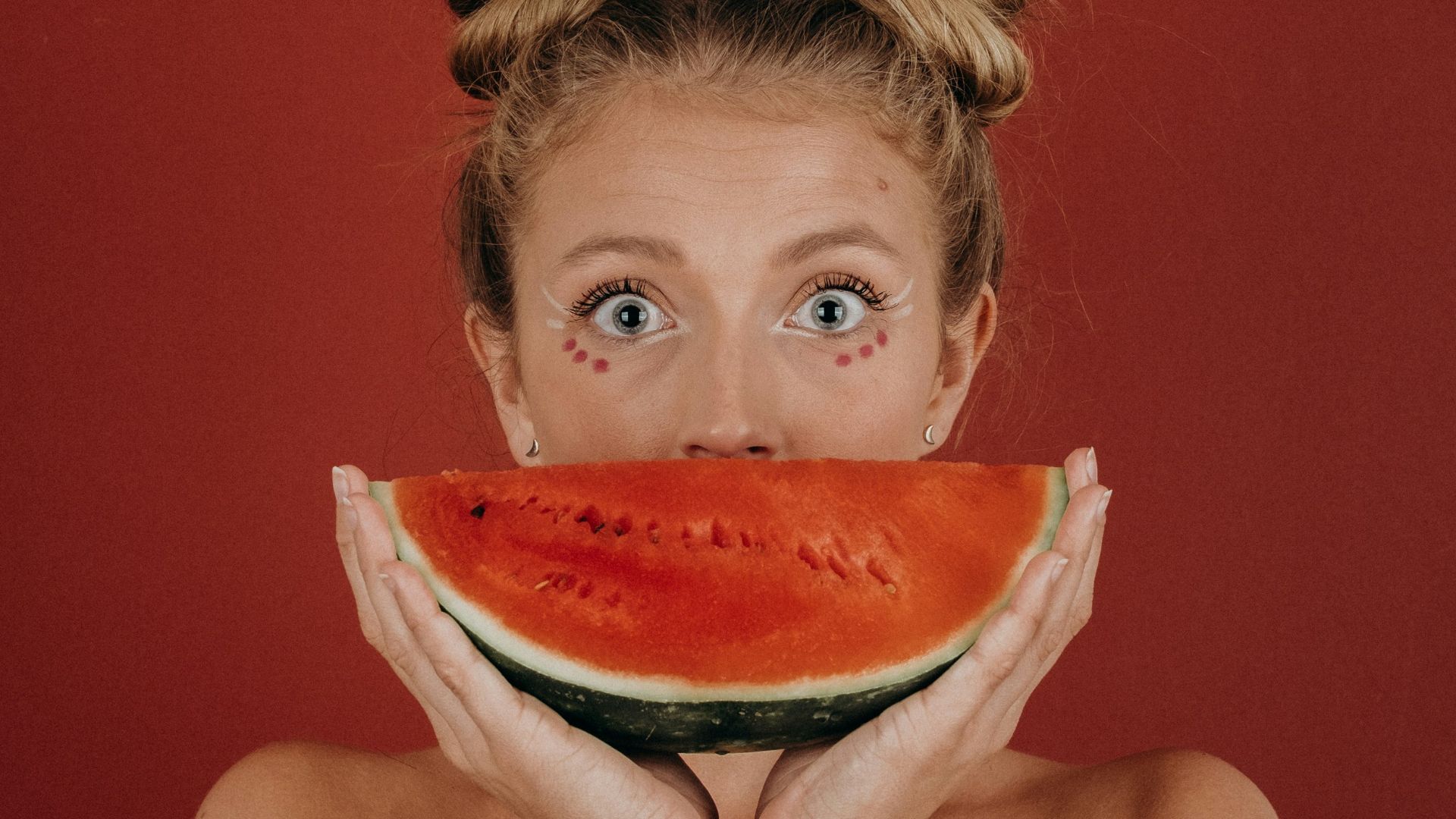 woman covering her mouth with watermelon
