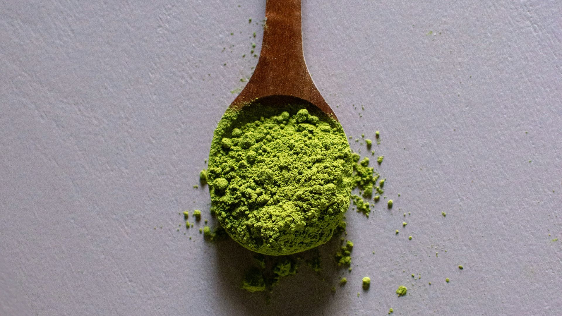 a wooden spoon filled with green powder