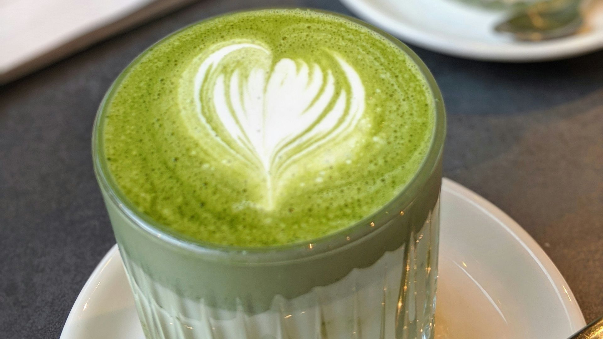 green and white floral cup on white ceramic saucer