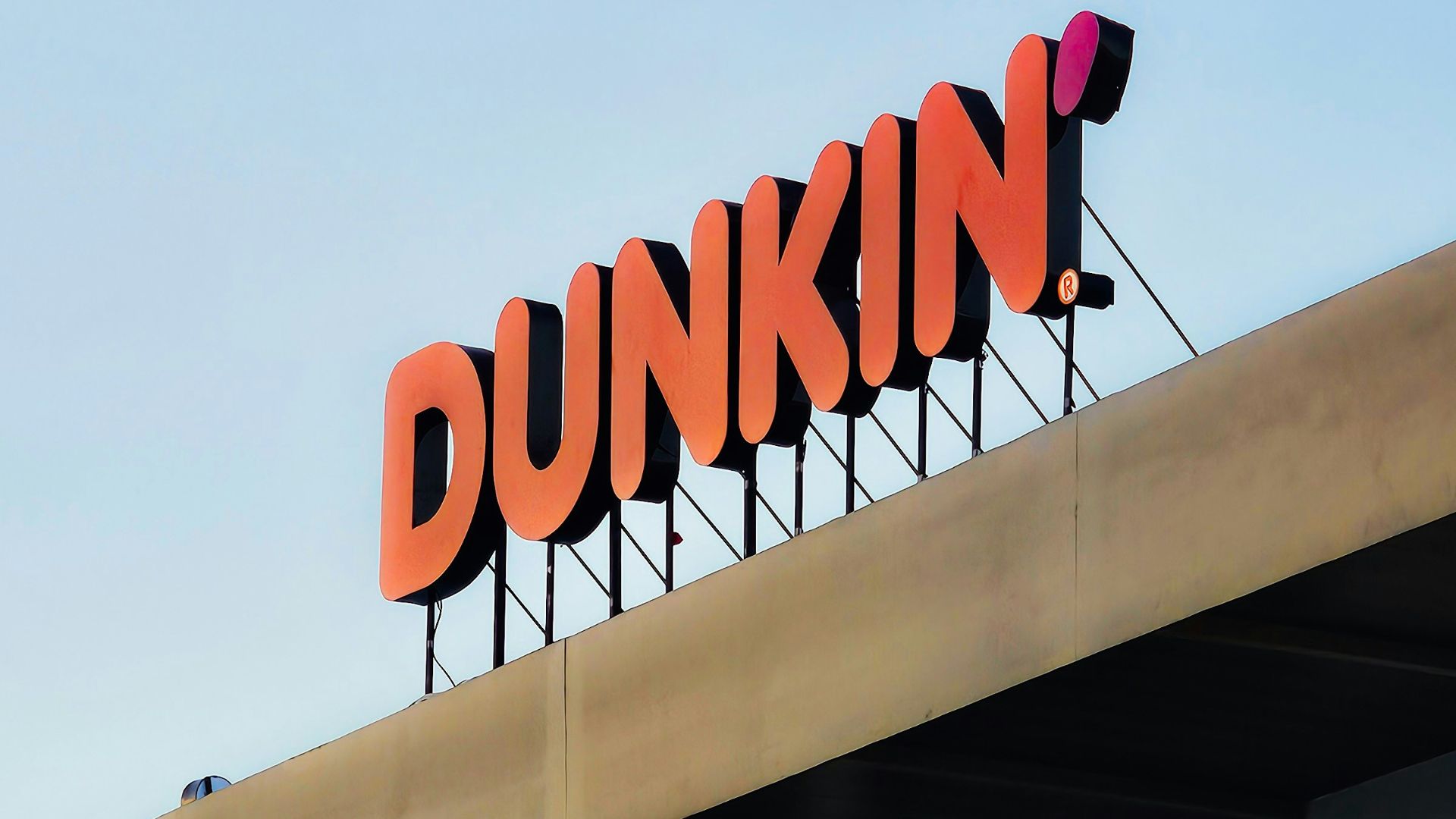 a dunkin'donuts sign on top of a building