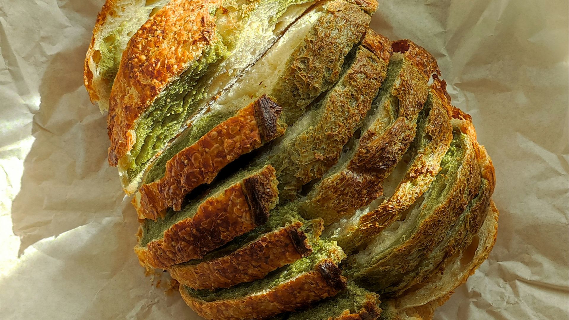 A sliced loaf of bread sitting on top of a piece of wax paper
