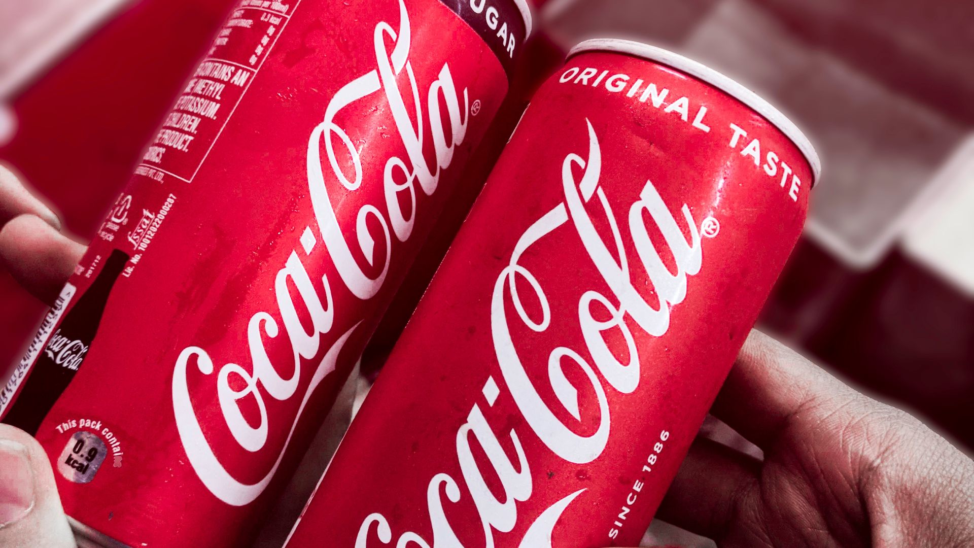 two red-and-white Coca-Cola cans