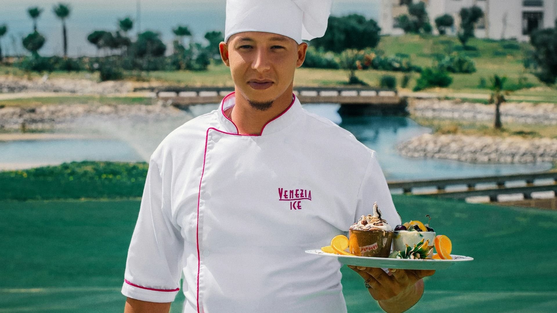 woman in white chef uniform holding green plate with food