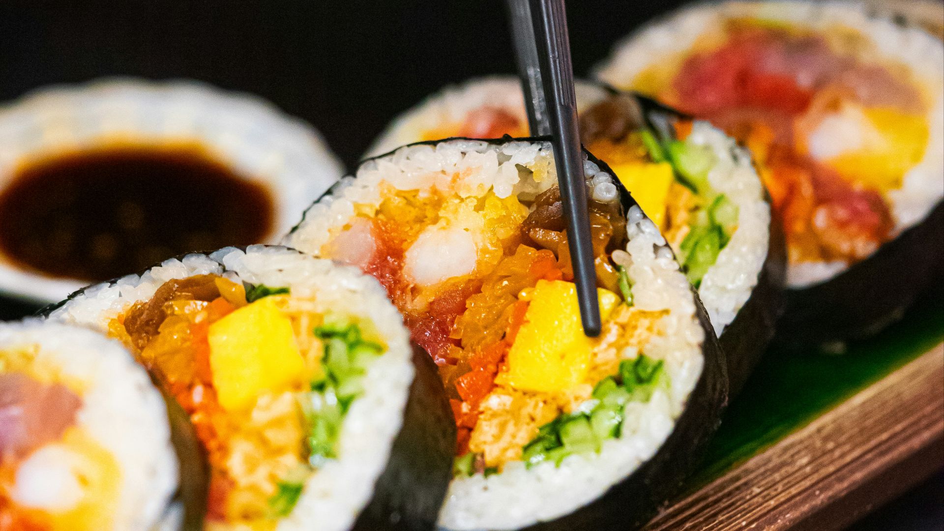 a person cutting into a sushi with chopsticks