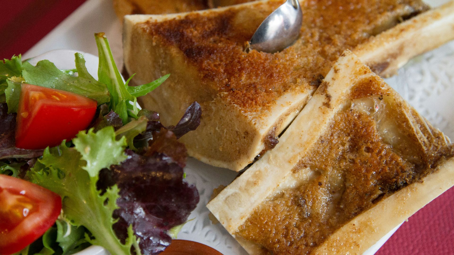 A white plate topped with toasted bread and a salad