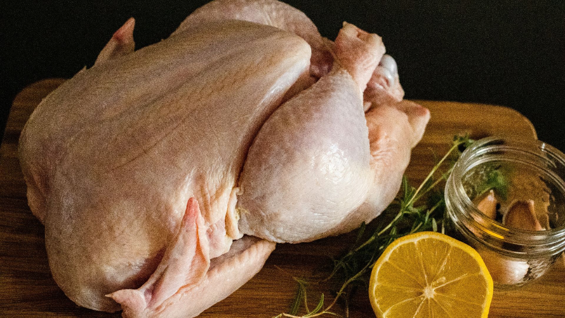 raw chicken meat on brown wooden chopping board