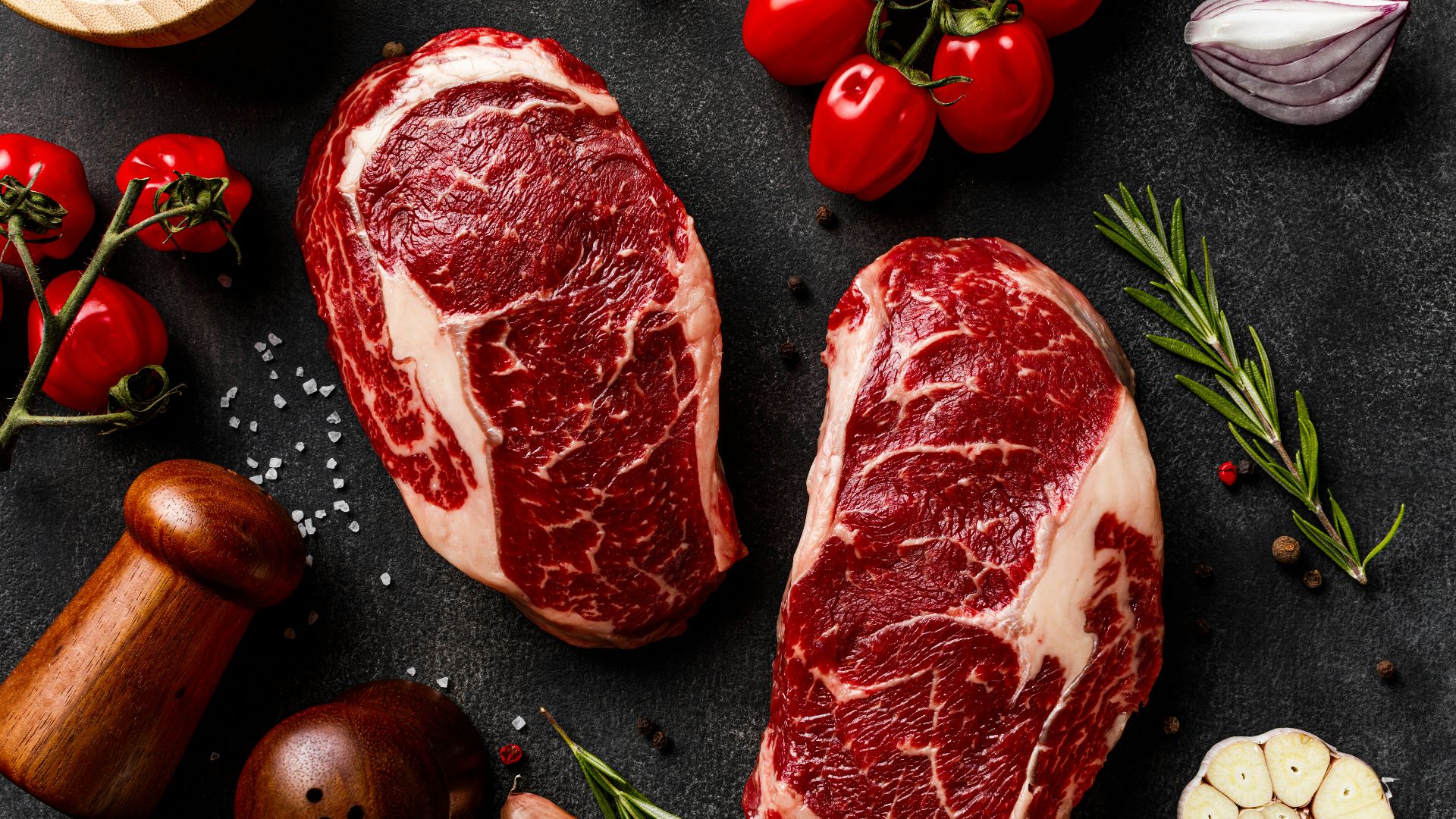 a couple of steaks sitting on top of a table