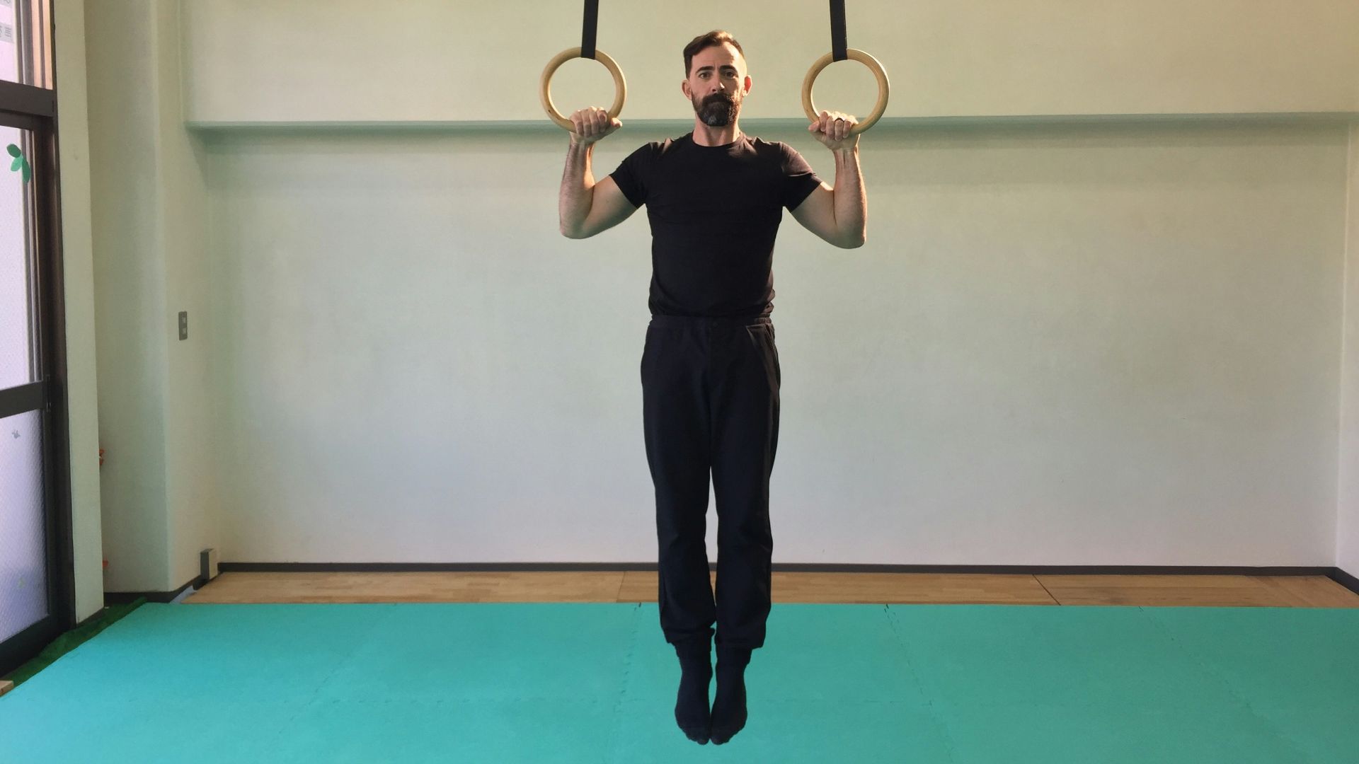 a man is doing a pull up exercise with two rings