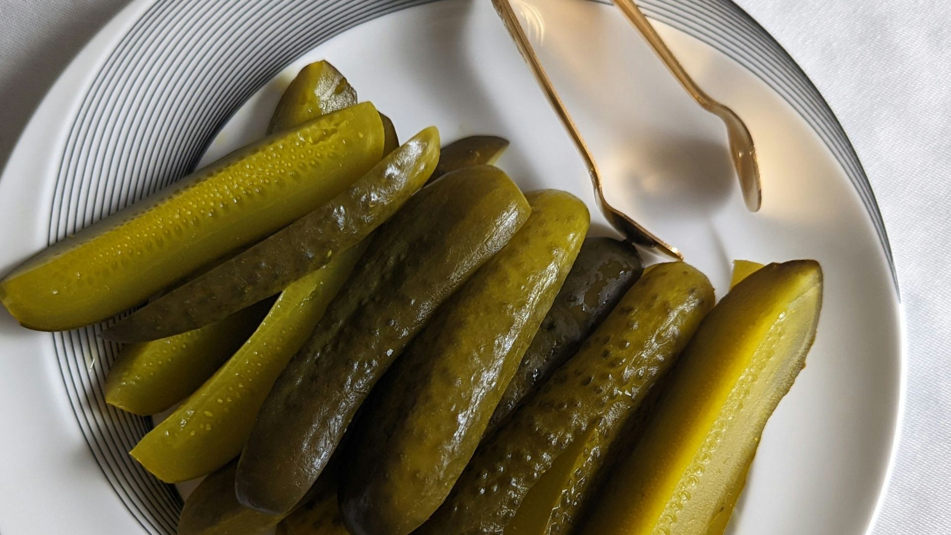 a white plate topped with pickles next to a fork