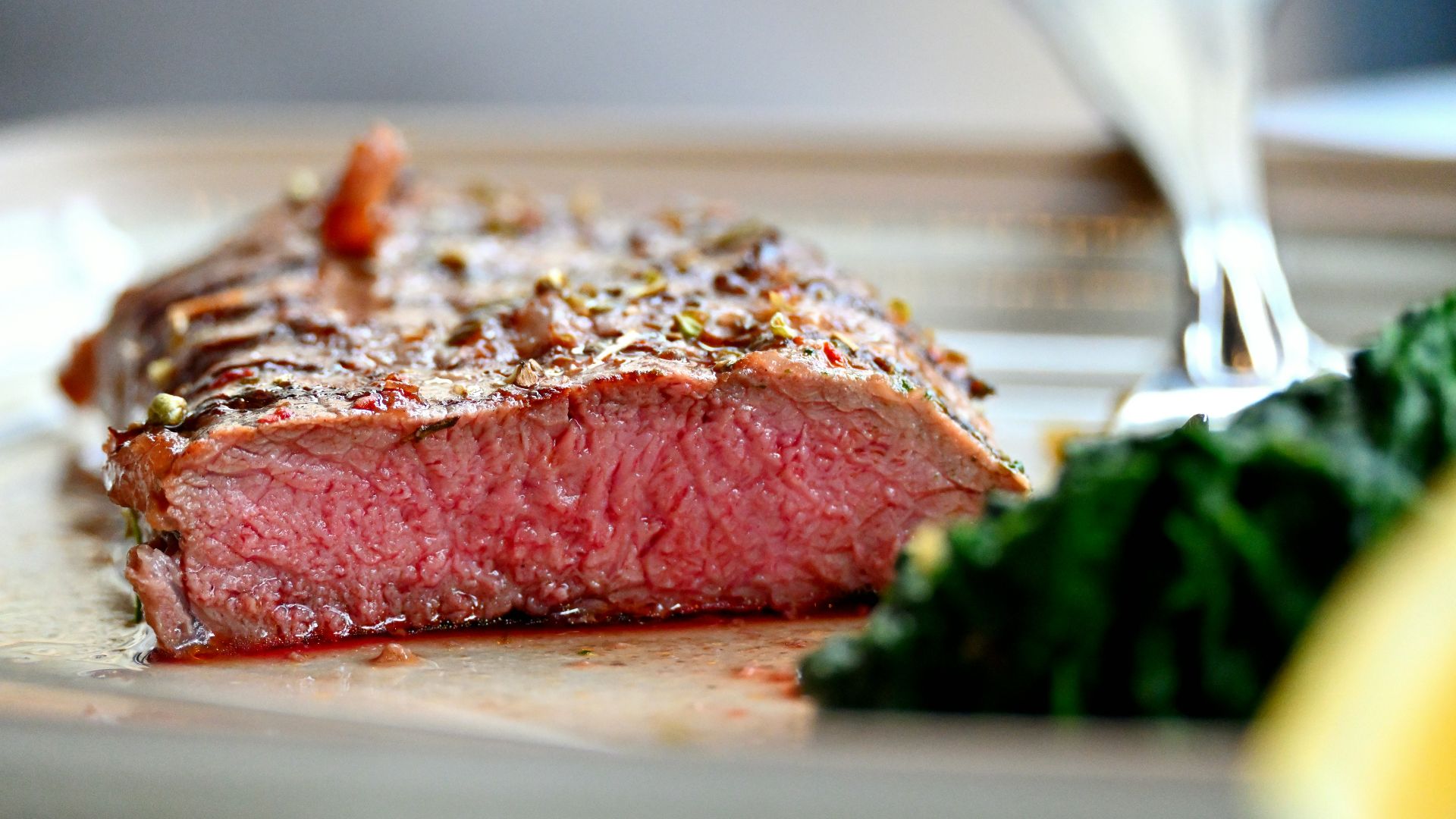 A piece of steak on a plate with a fork