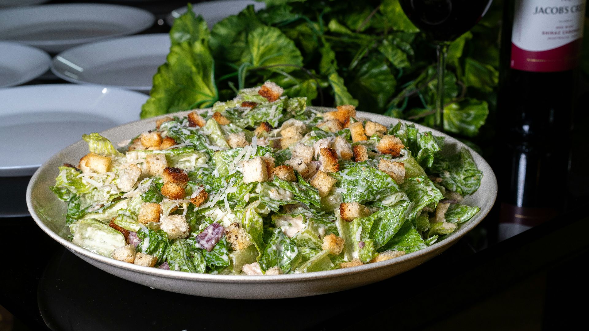 Delicious caesar salad is presented on a table.