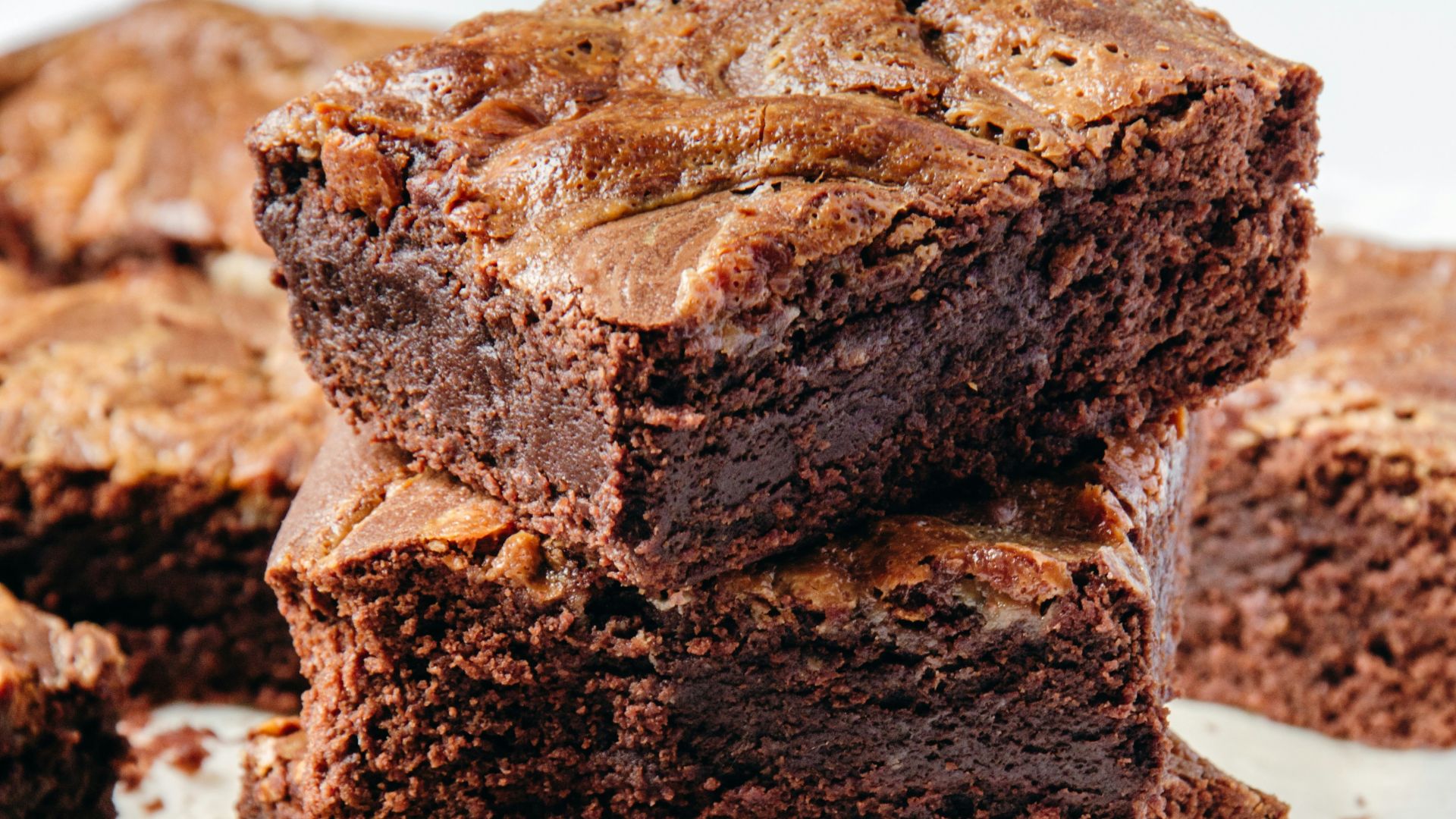 a pile of brownies sitting on top of a white plate