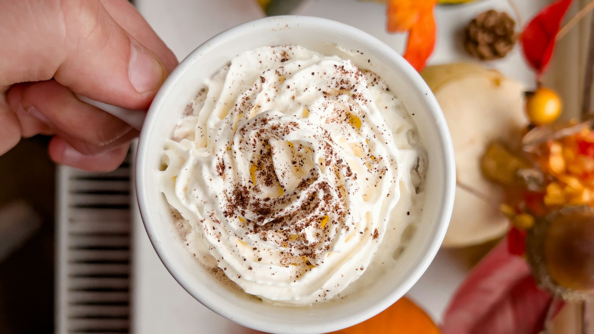 a person holding a cup of whipped cream