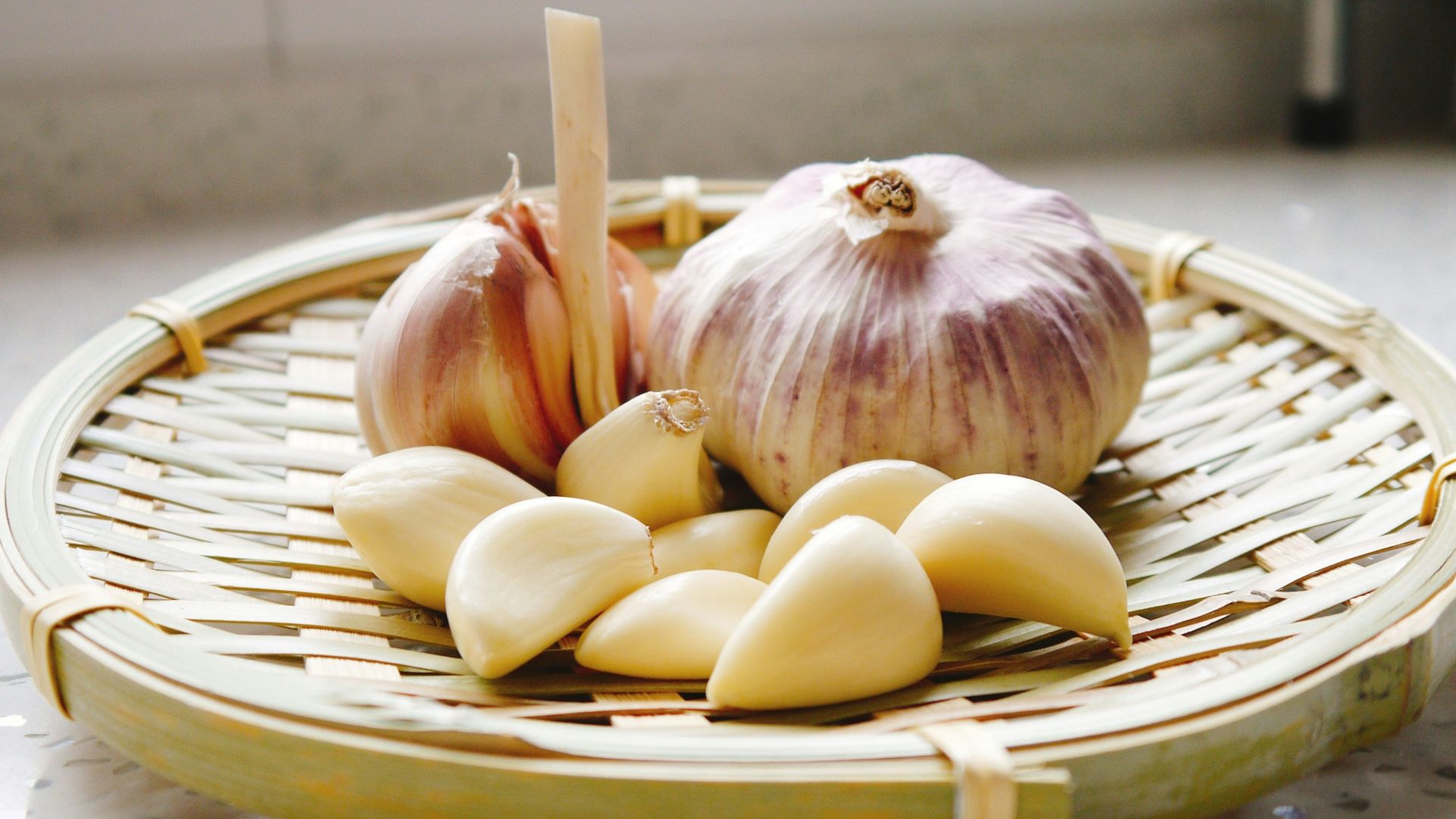 a basket of garlic and garlic bulbs on a counter