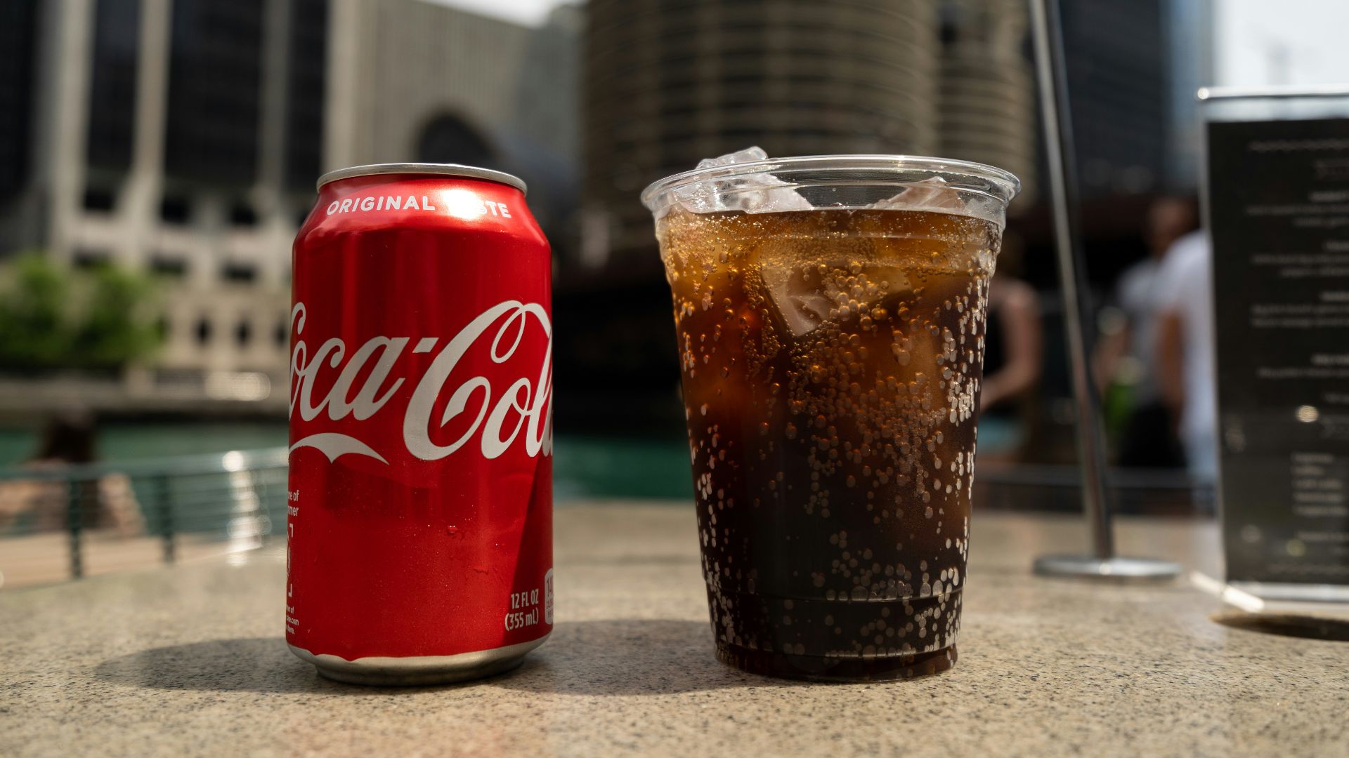 Coca-Cola soda tin can and cup on table close-up photography