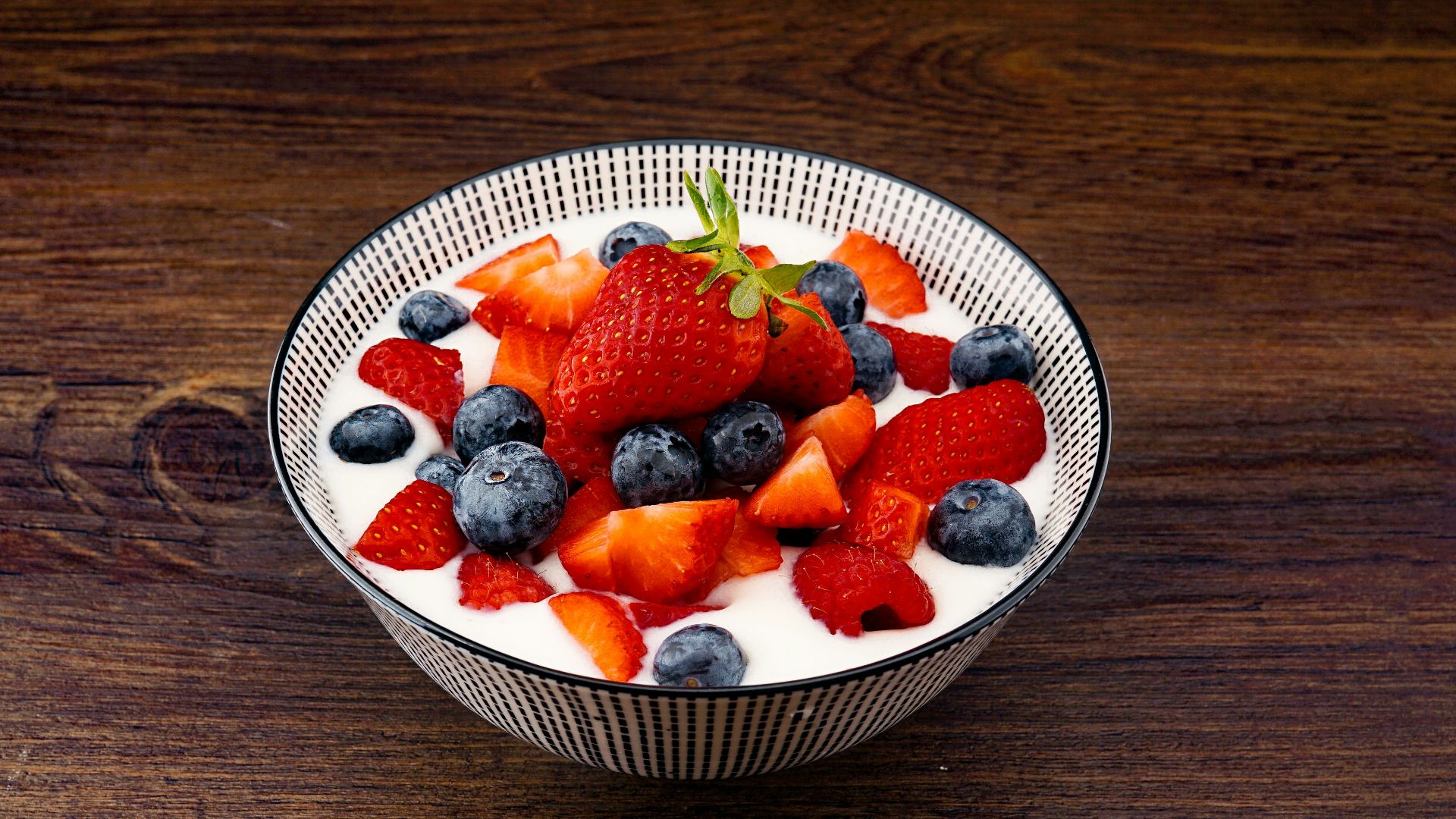strawberry and blackberries on top of brown table