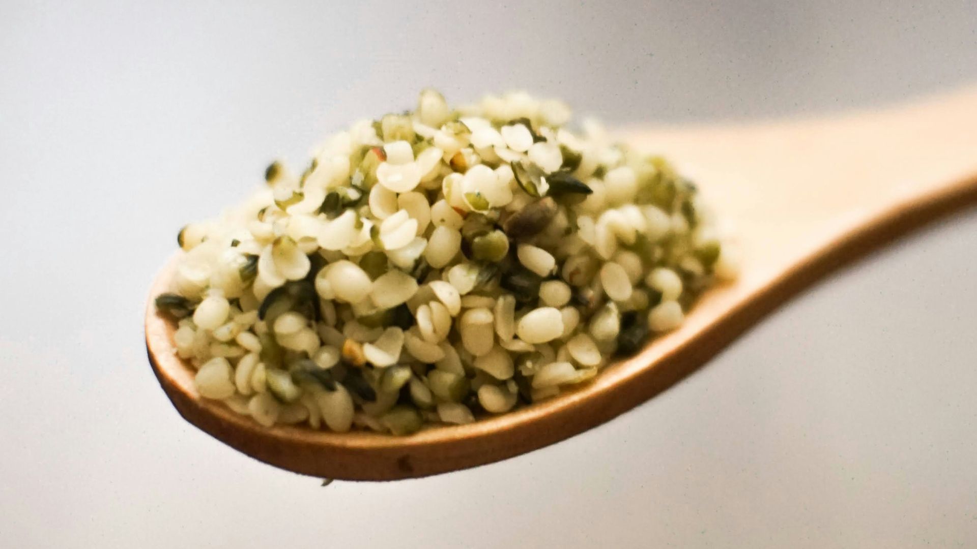 a wooden spoon filled with green food on top of a table