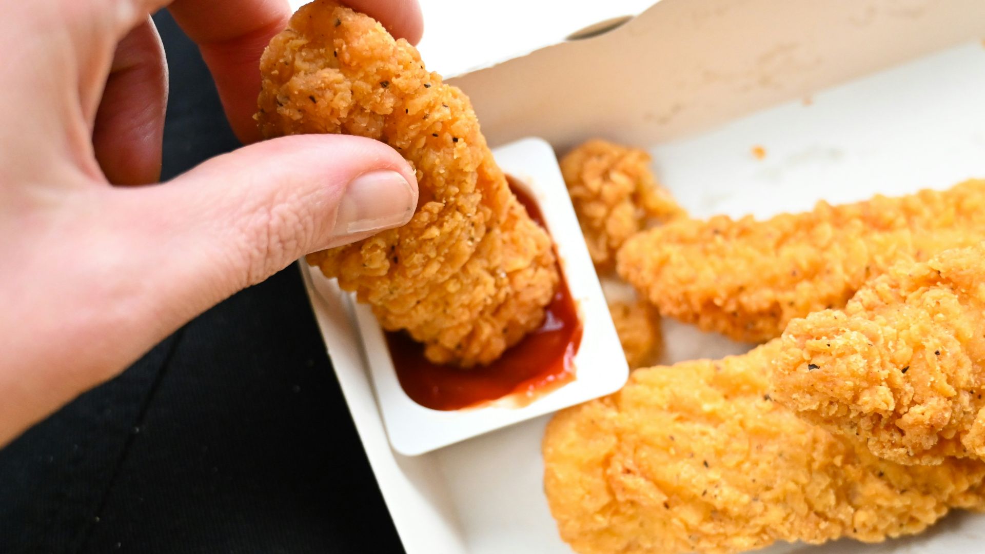 a person is dipping something into a container