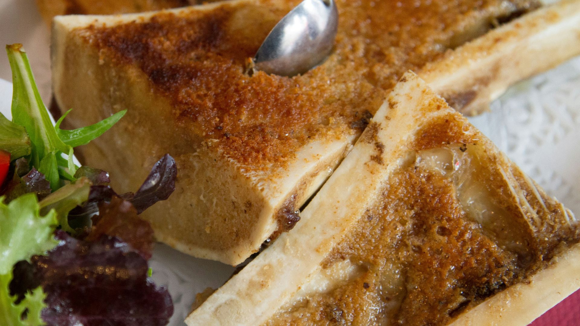 A white plate topped with toasted bread and a salad