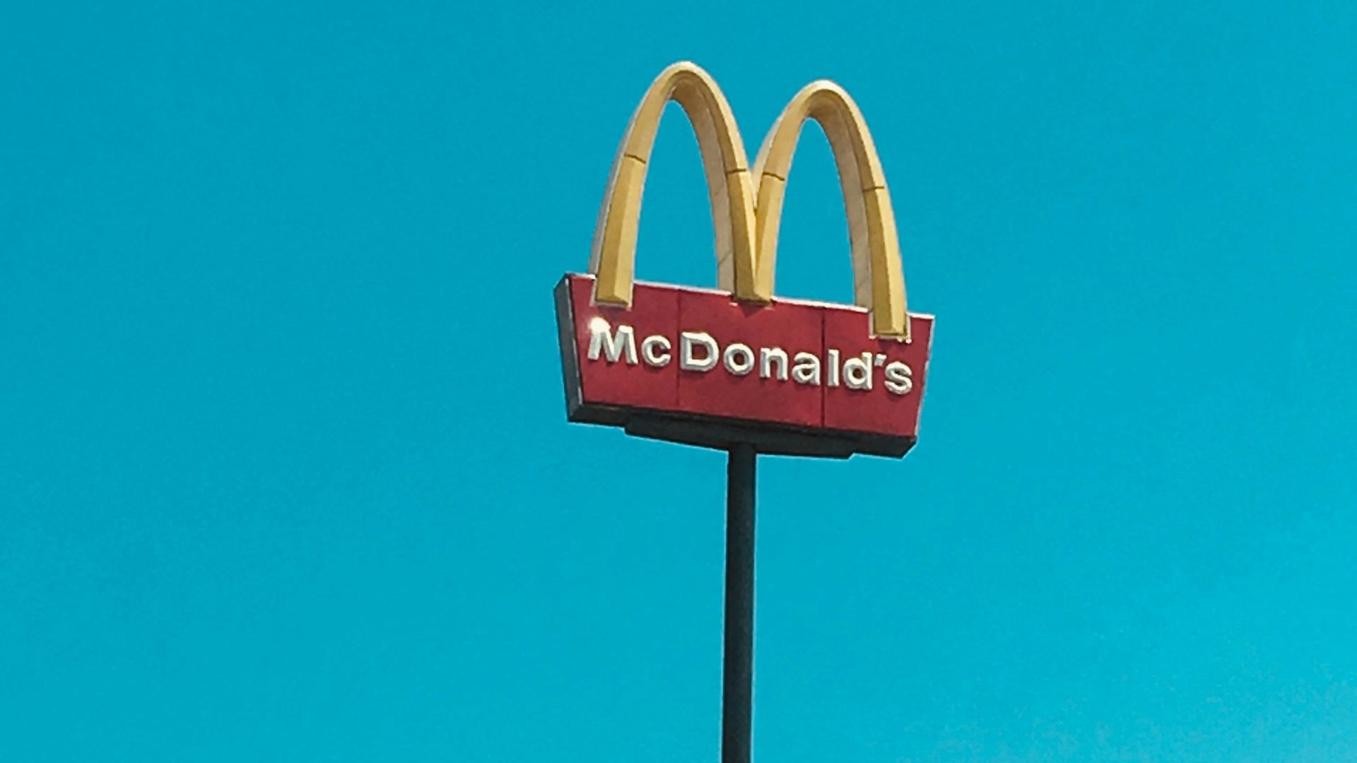 a mcdonald's restaurant sign in front of a blue sky