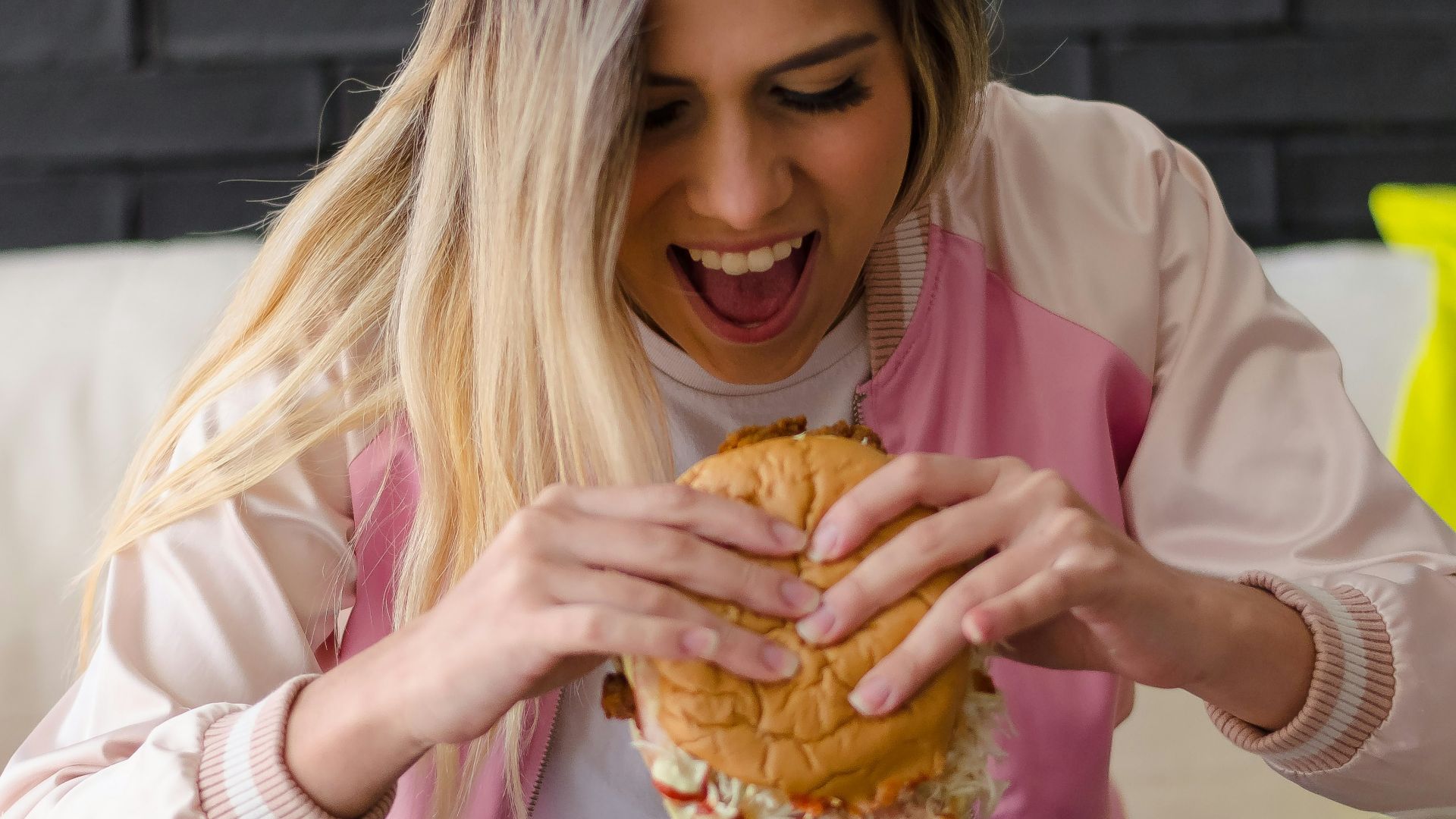 girl in pink long sleeve shirt eating bread