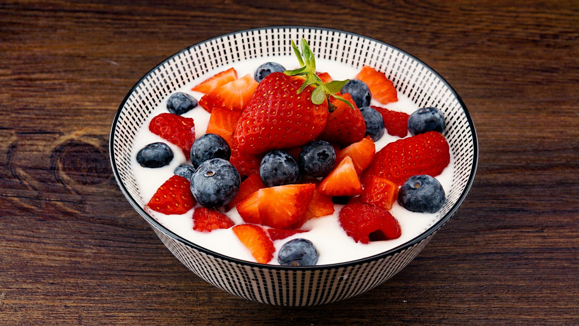 strawberry and blackberries on top of brown table