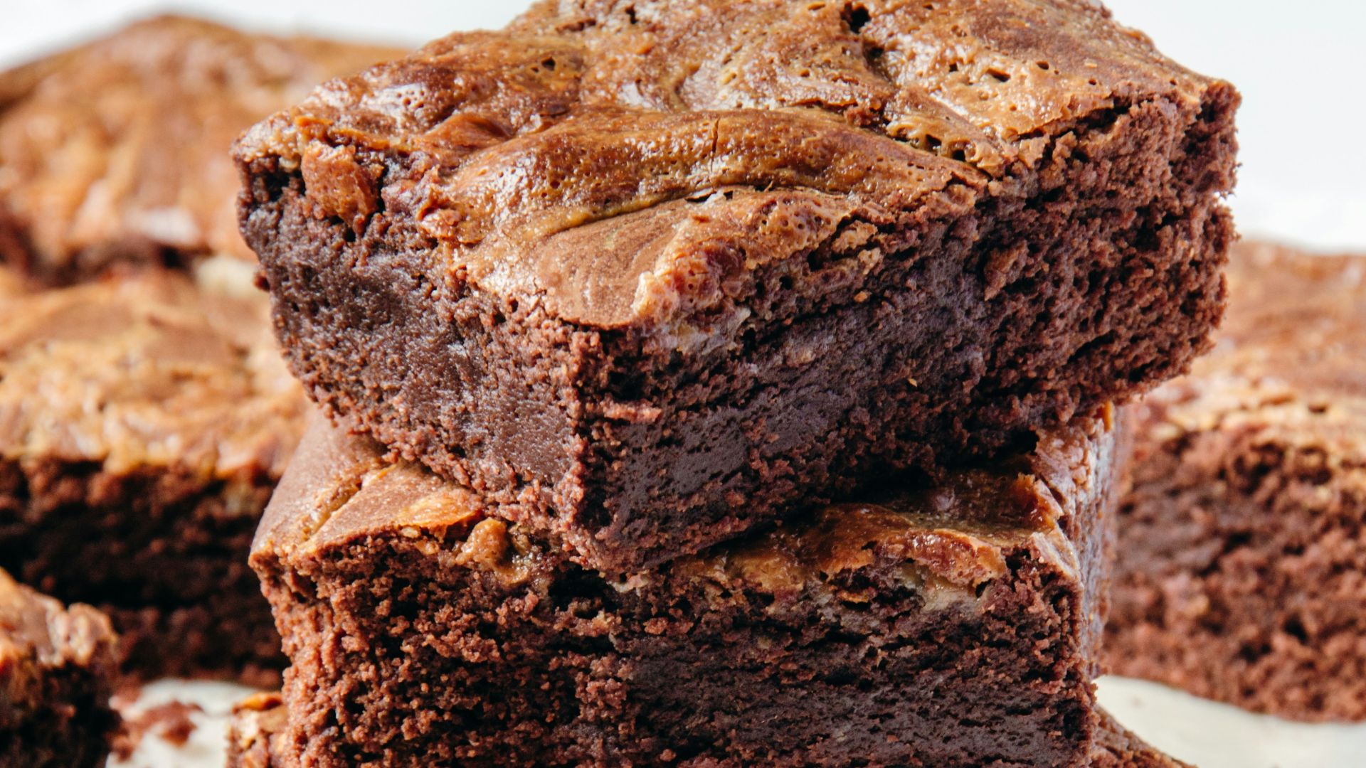 a pile of brownies sitting on top of a white plate