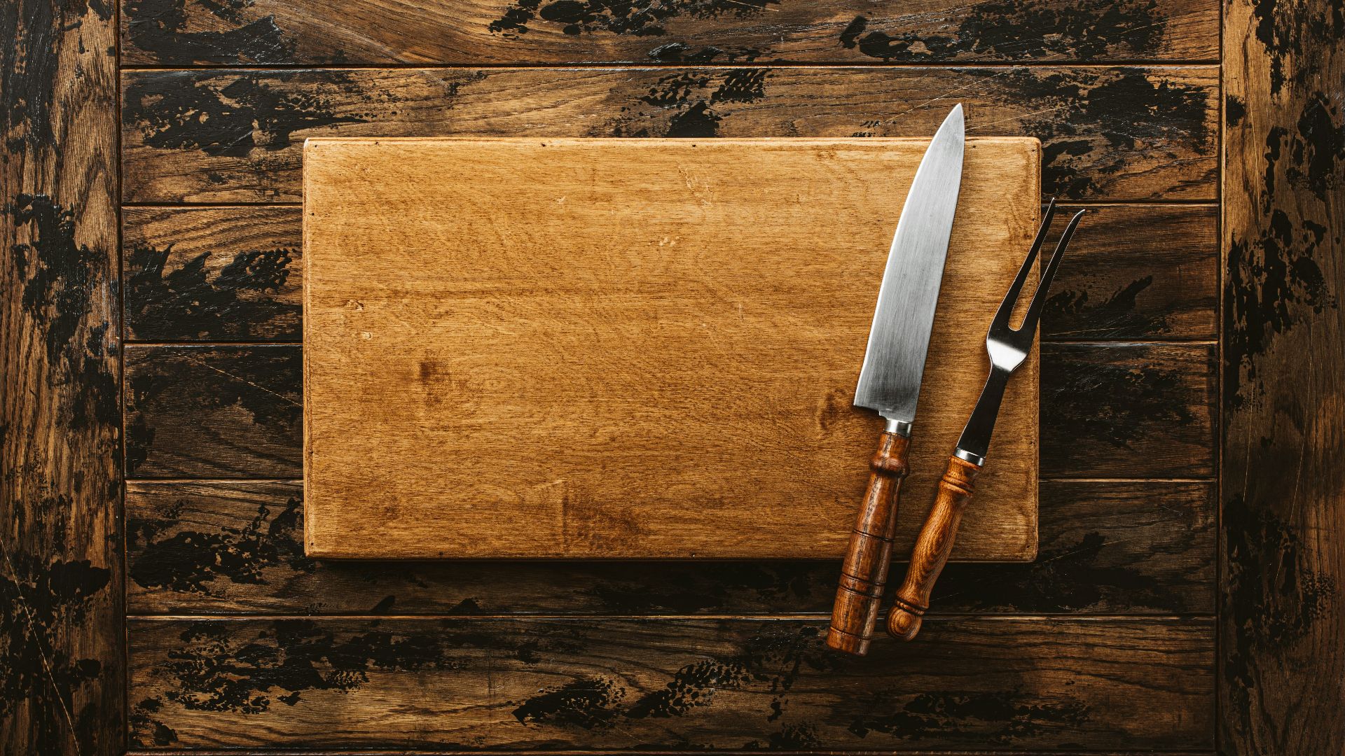 a knife and a board on a wooden surface