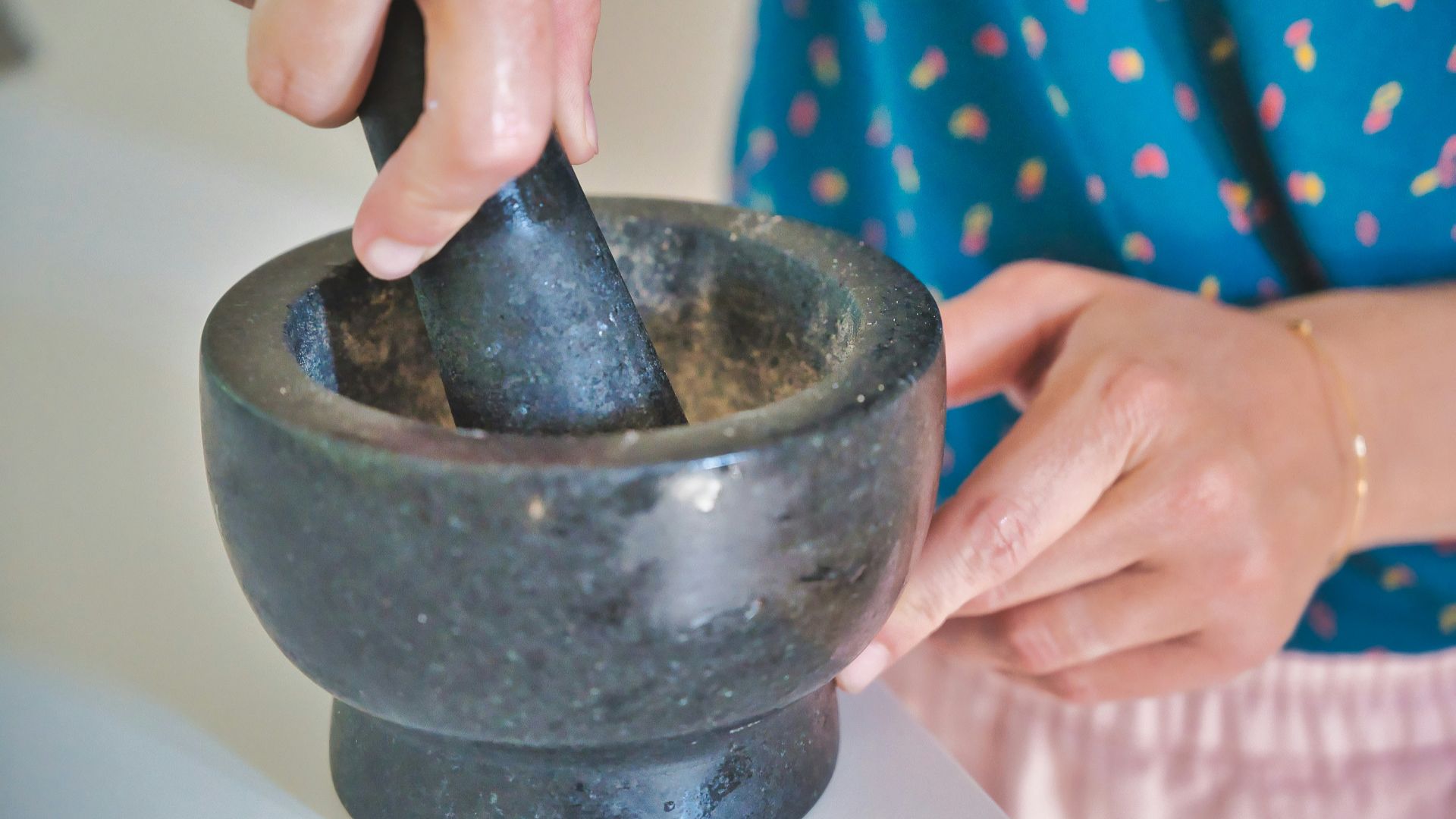 person holding gray mortar and pestle
