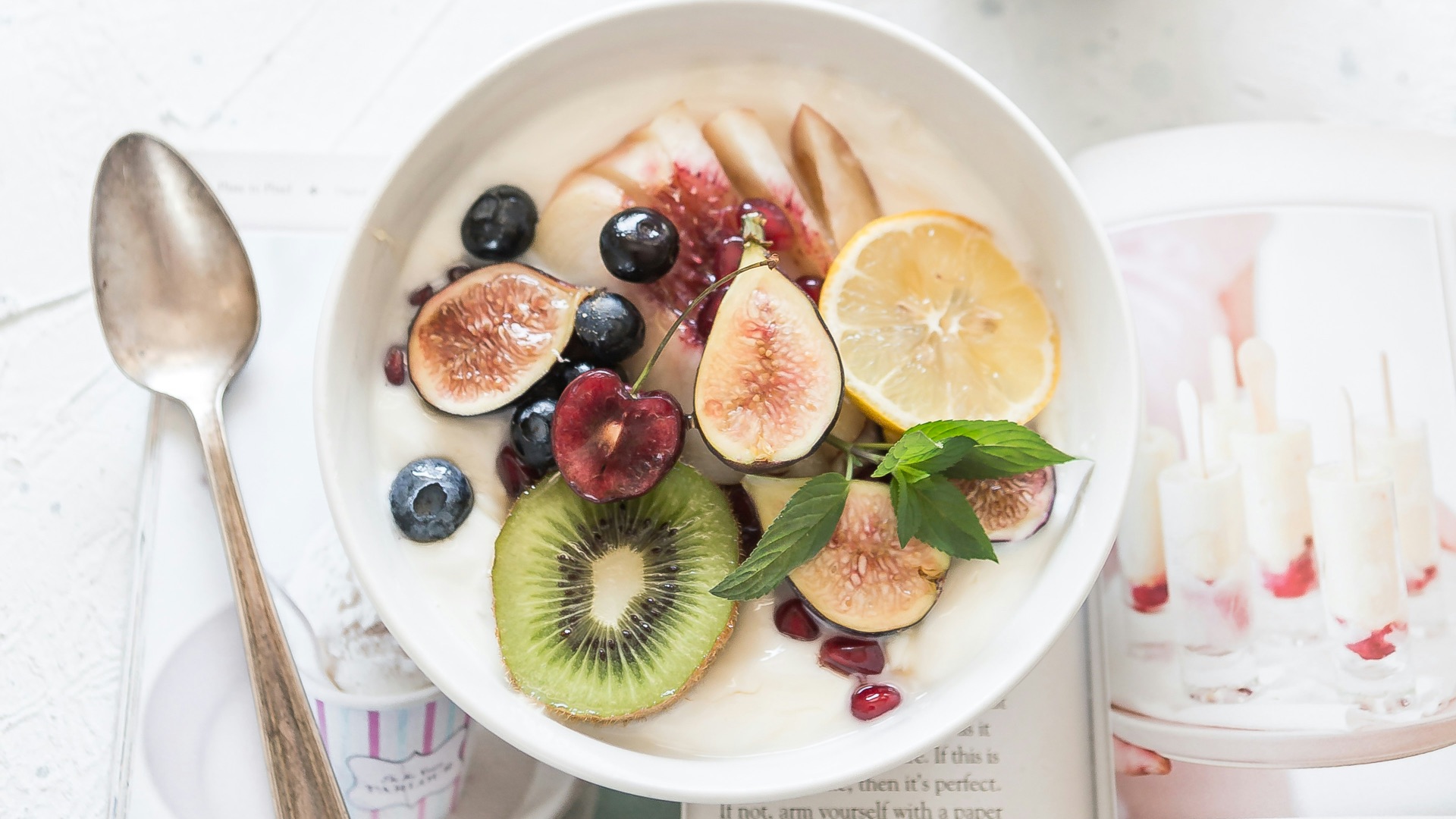 white ceramic plate beside gray steel spoon