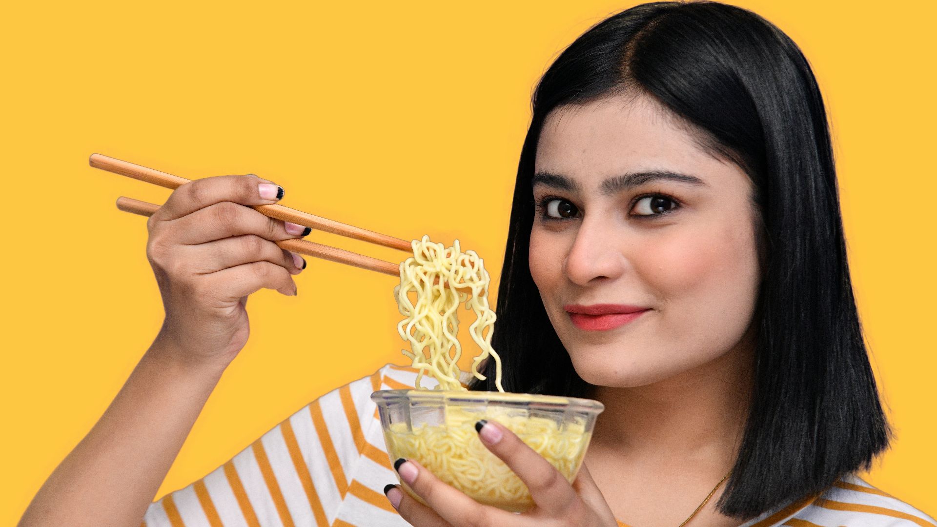 a woman holding a bowl of noodles