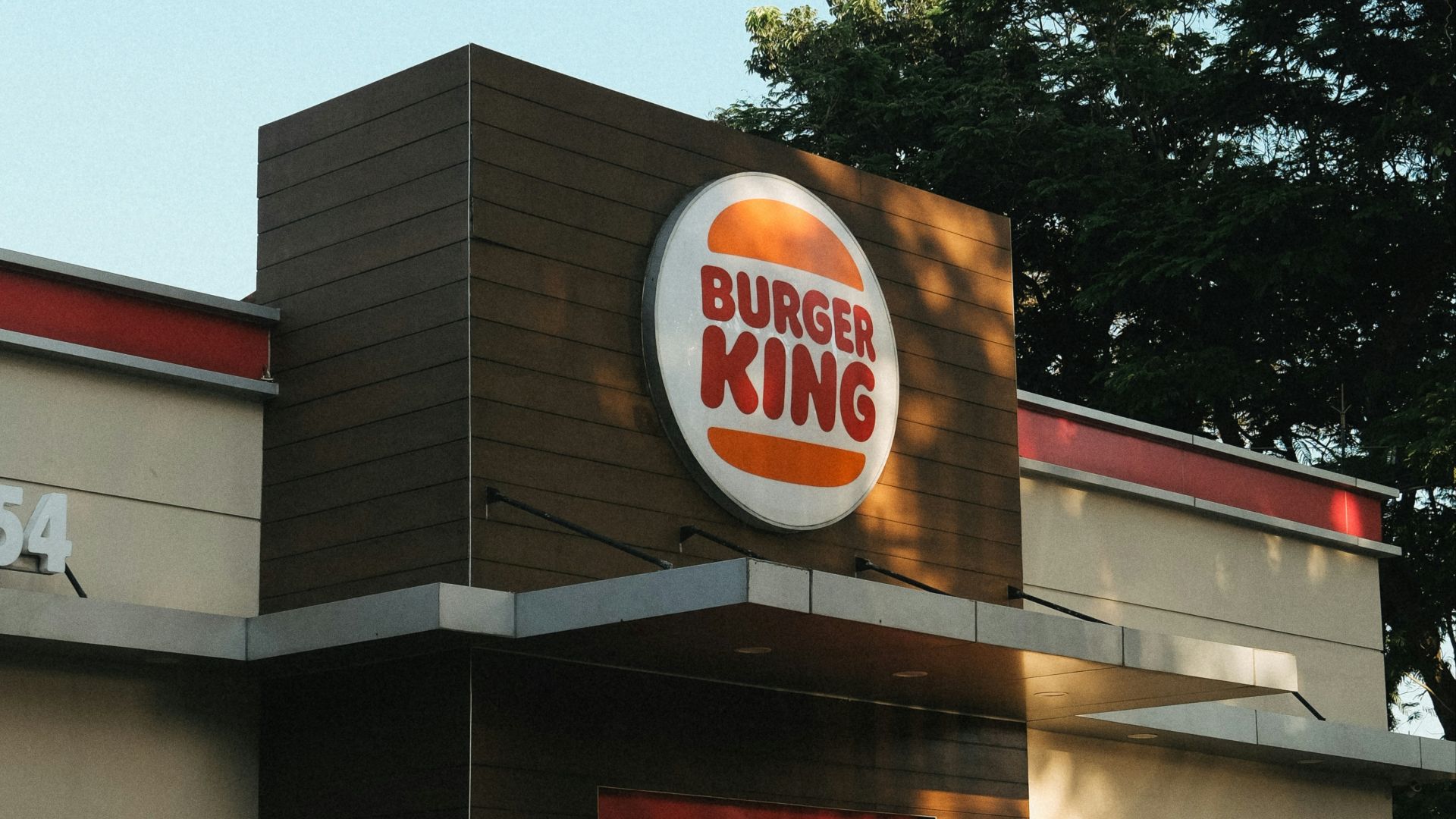 a burger king restaurant with a man standing outside