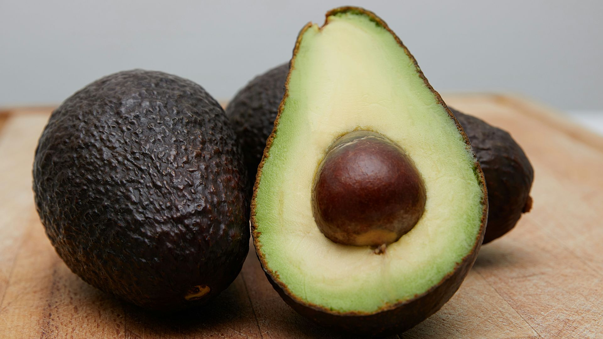 sliced avocado fruit on brown wooden table