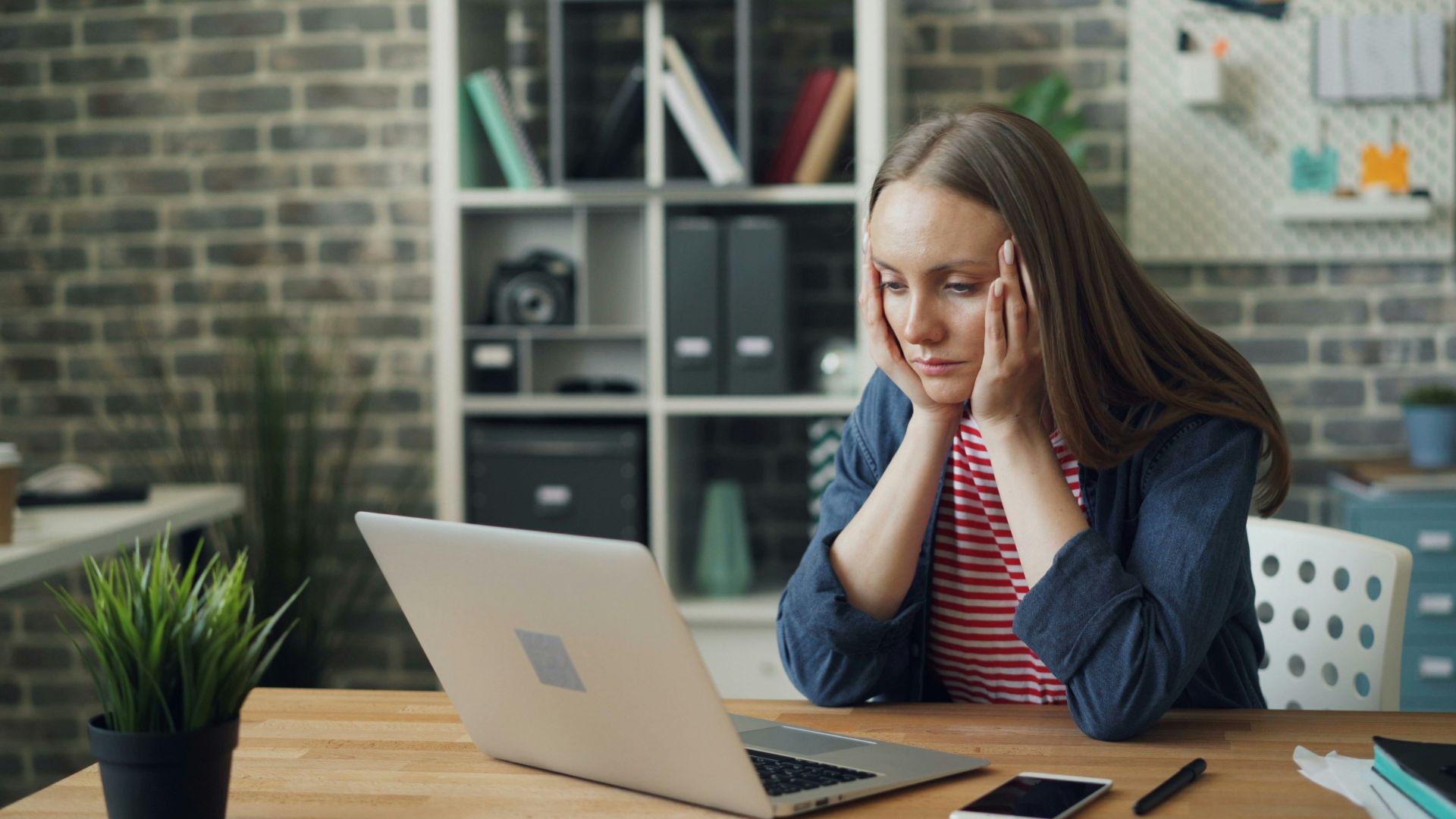 a woman sitting at a table with a laptop in front of her