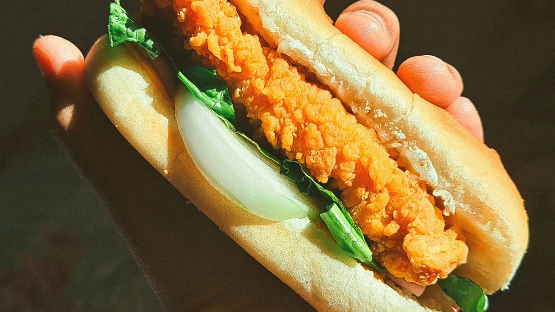 a person holding a sandwich in their hand