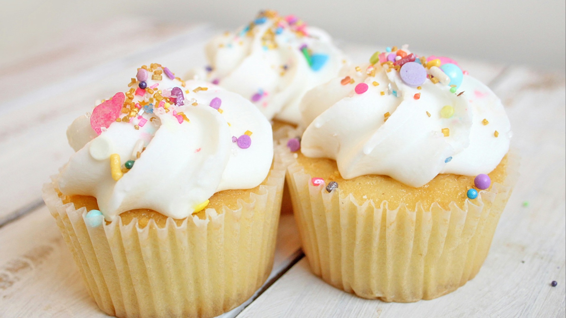 three cupcakes on white wood