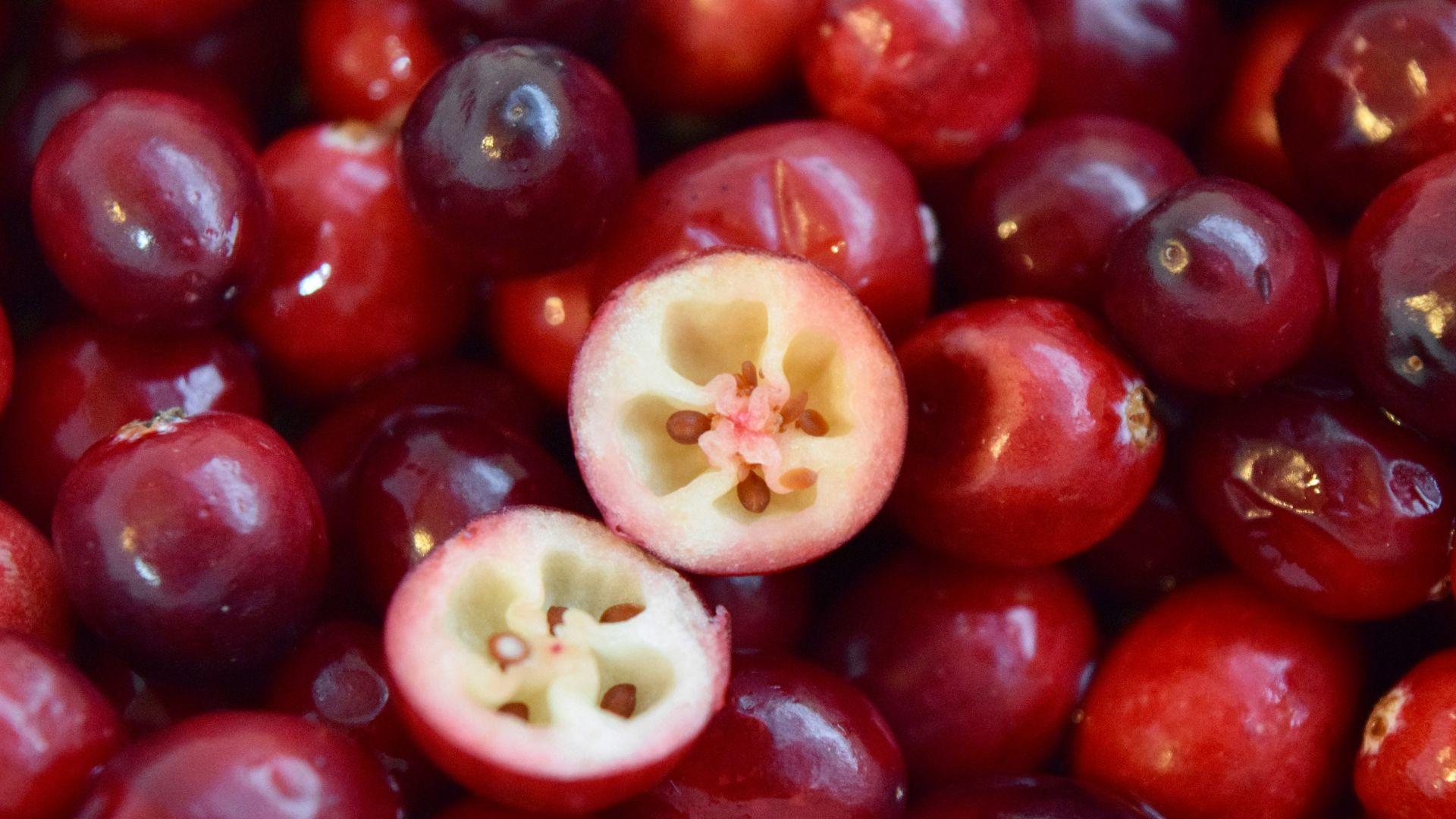 a pile of cherries with one cut in half