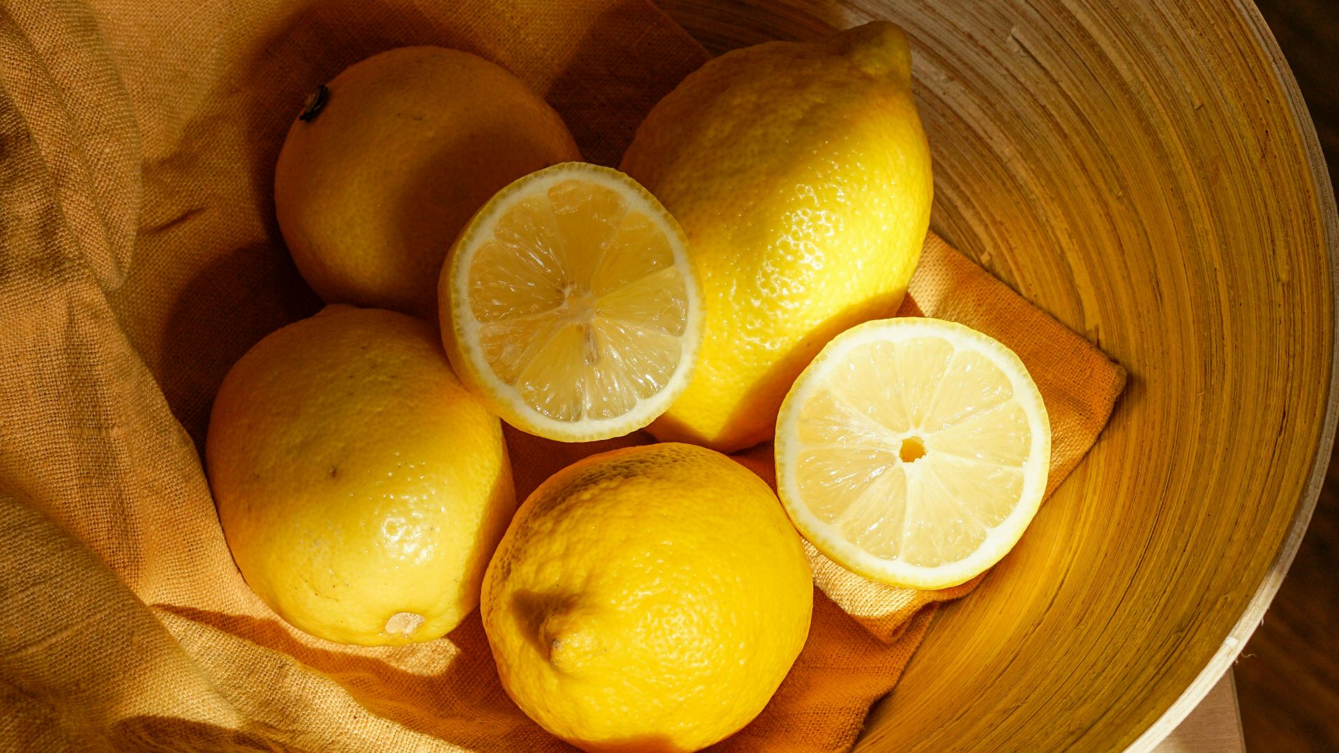 yellow lemon fruit in brown wooden bucket