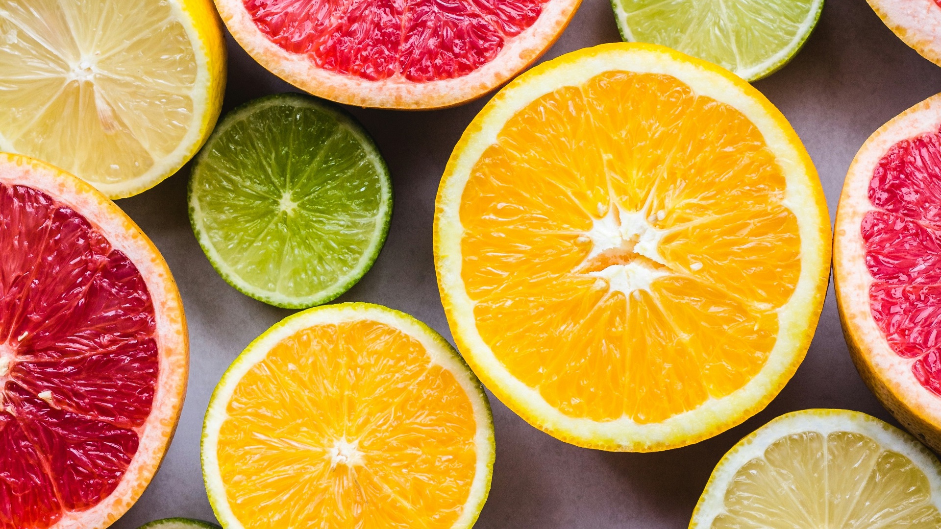 flat lay photography of sliced pomegranate, lime, and lemon