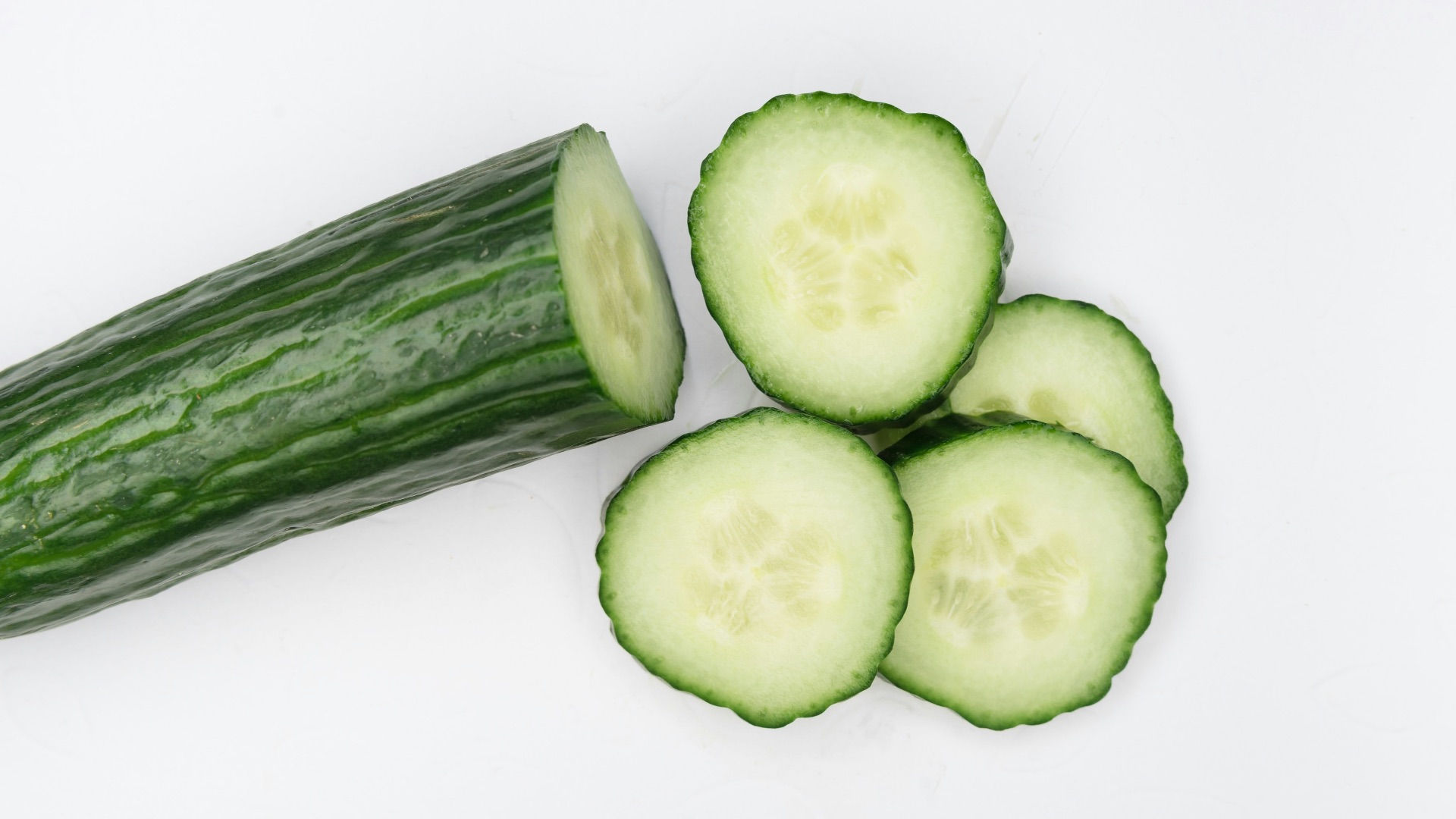 sliced cucumber on white surface