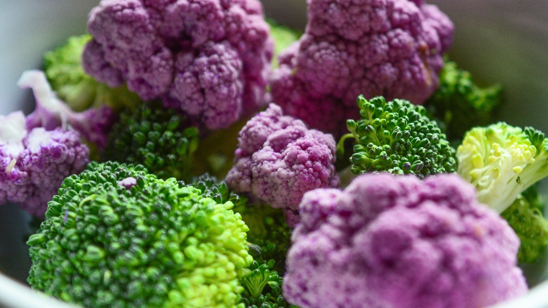 A white bowl filled with purple and green broccoli