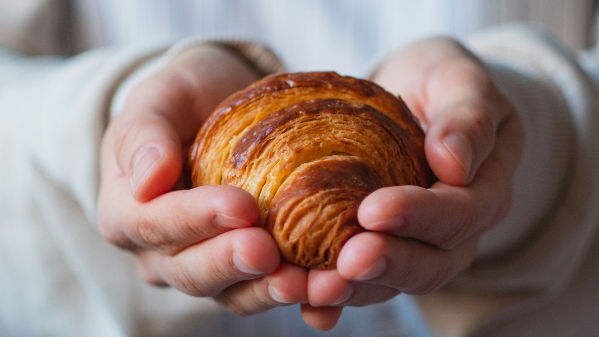 a person holding a pastry in their hands