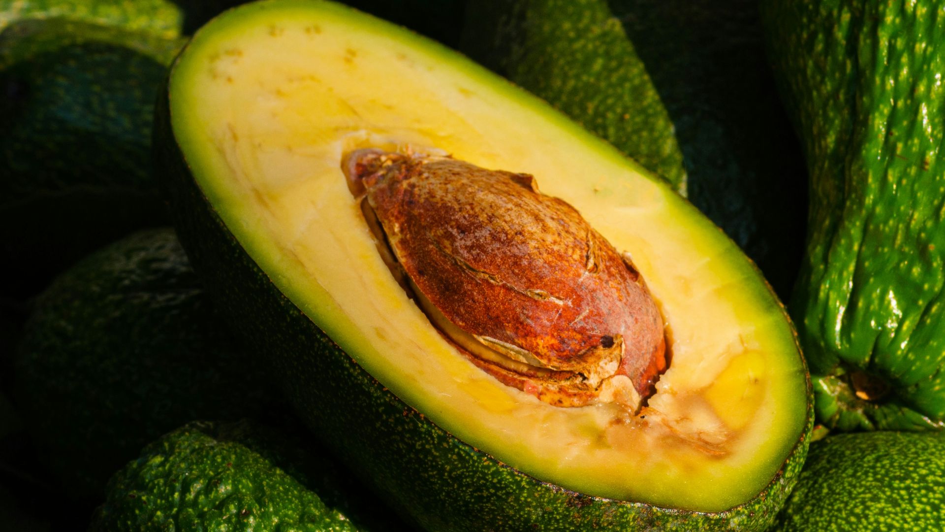 a pile of green avocados sitting on top of each other