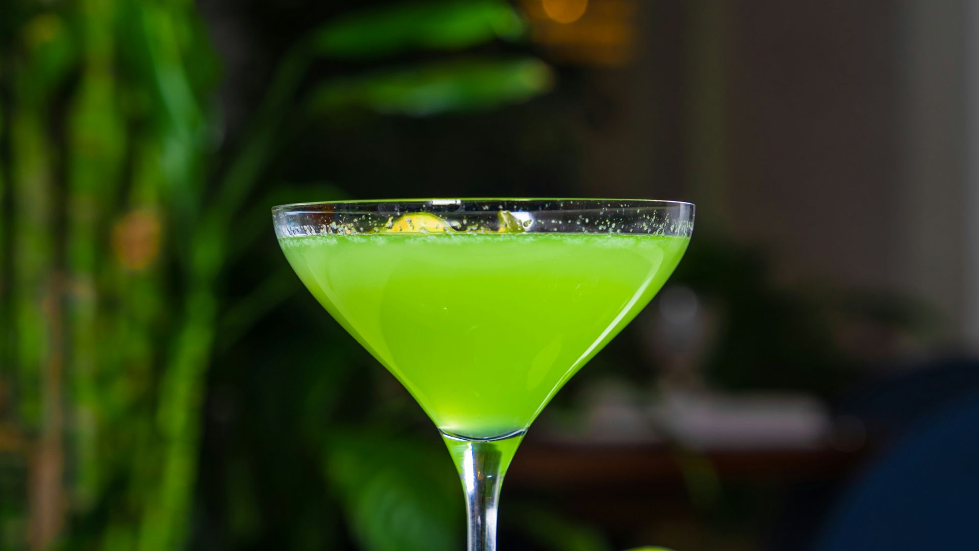 a green drink sitting on top of a table