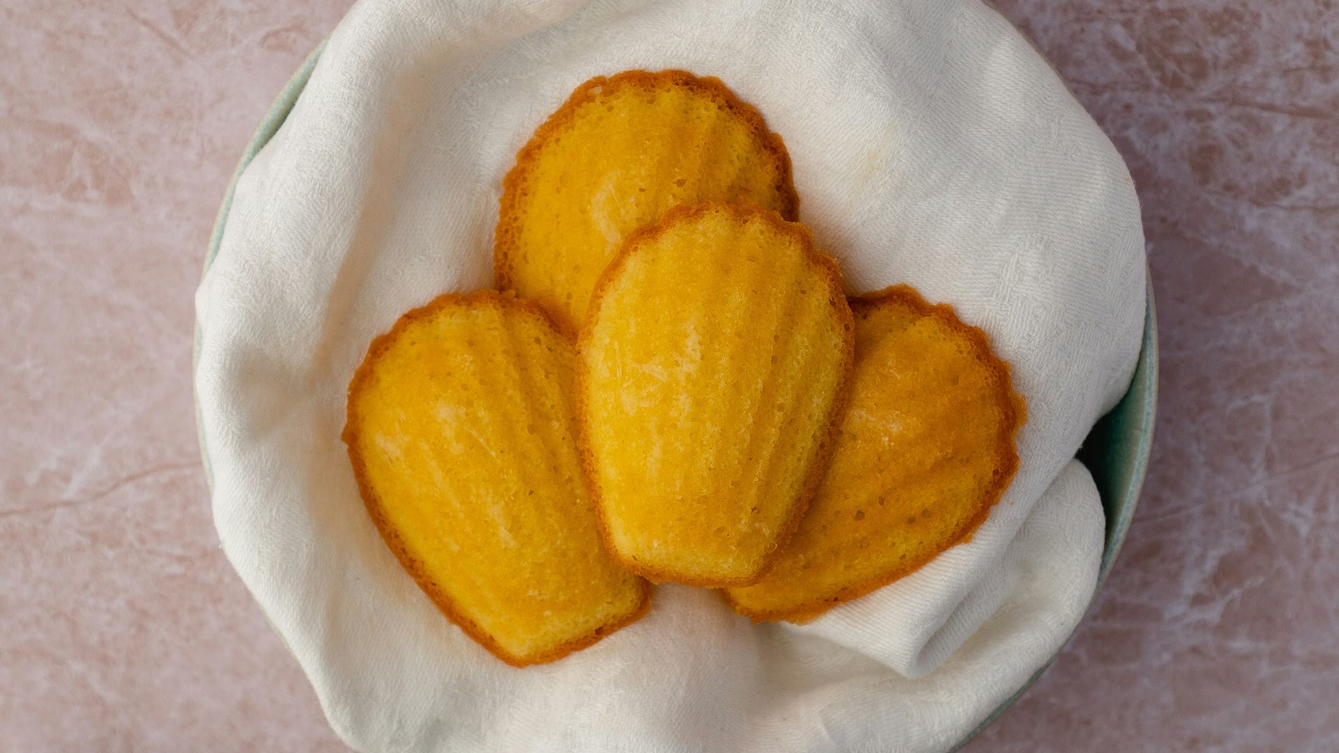 a bowl of peeled oranges next to a plate of sliced oranges