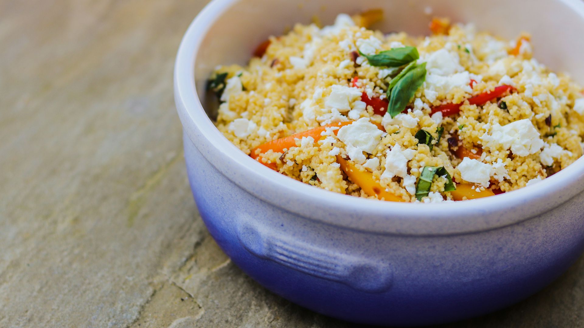 a blue bowl filled with food on top of a wooden table