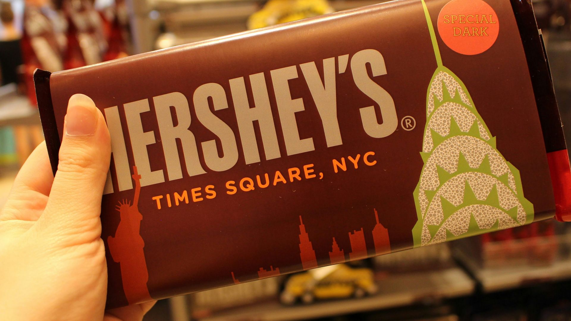 person holding orange and white labeled pack