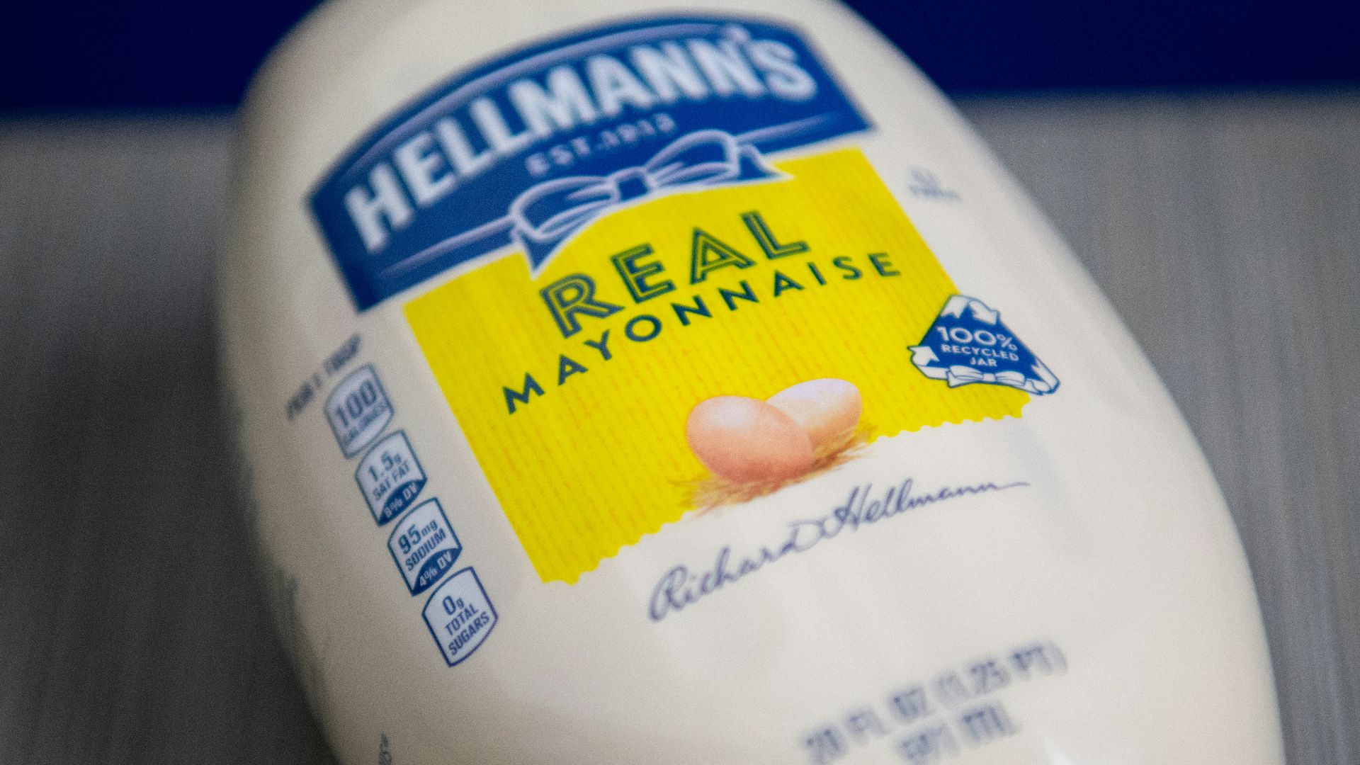 a hand holding a white container