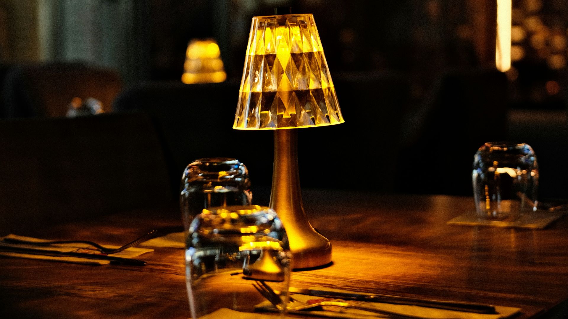 Table setting with illuminated lamp in dim restaurant